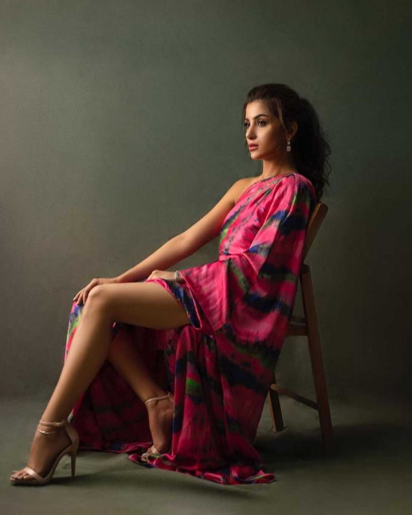 Sohai Ali Abro looks hot wearing a pink dress while sitting on a chair displaying her toned legs