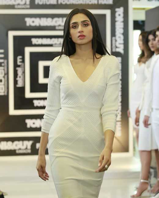 A picture of the actress Mashal Khan on the runway of Pakistan Fashion Week wearing a white dress