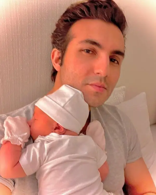 An image of Shahroz Sabzwari holding his newborn daughter