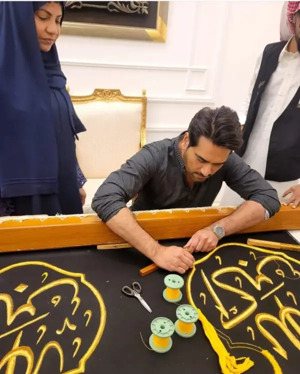 A picture of Humayun Saeed with his wife while they are sewing Ghilaf e Kaaba