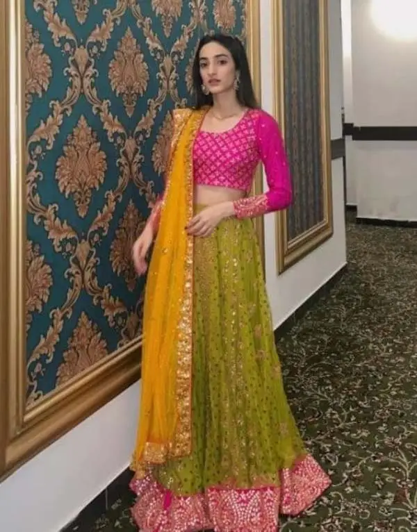 A picture of the bride wearing a yellow mayun dress at her home