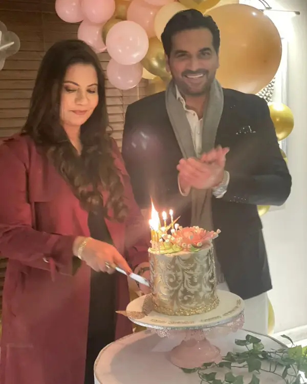 A photo of Samina with her husband cutting her birthday cake.