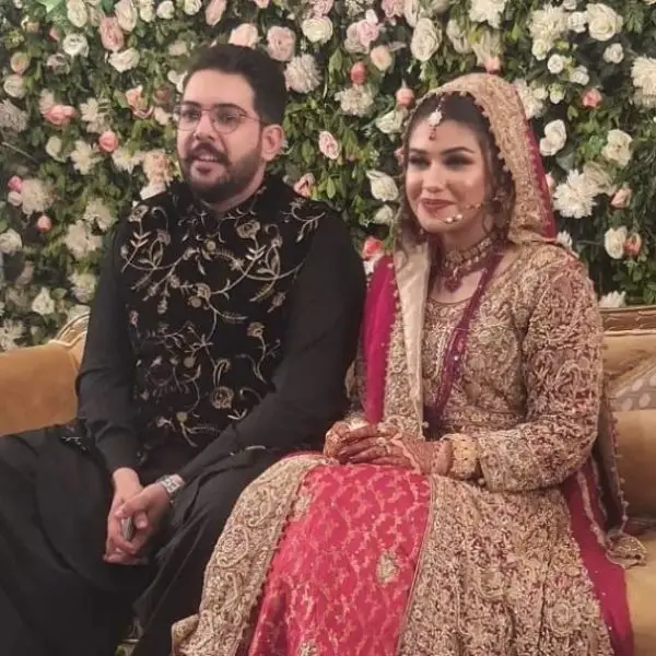 Ahmed Nizami and his wife on stage, smiling for the camera during a wedding shoot