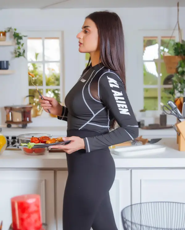 The actress poses in a kitchen wearing a very blod outfit