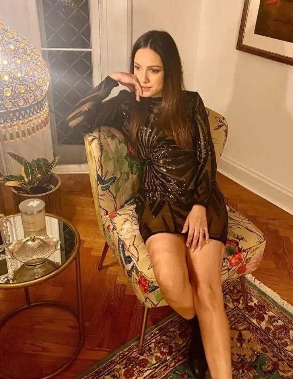 A black dress looks deeper on the model while she is at her home in the USA