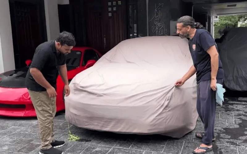 A Picture of Ducky Bhai removing the cover from his dream car in his garage