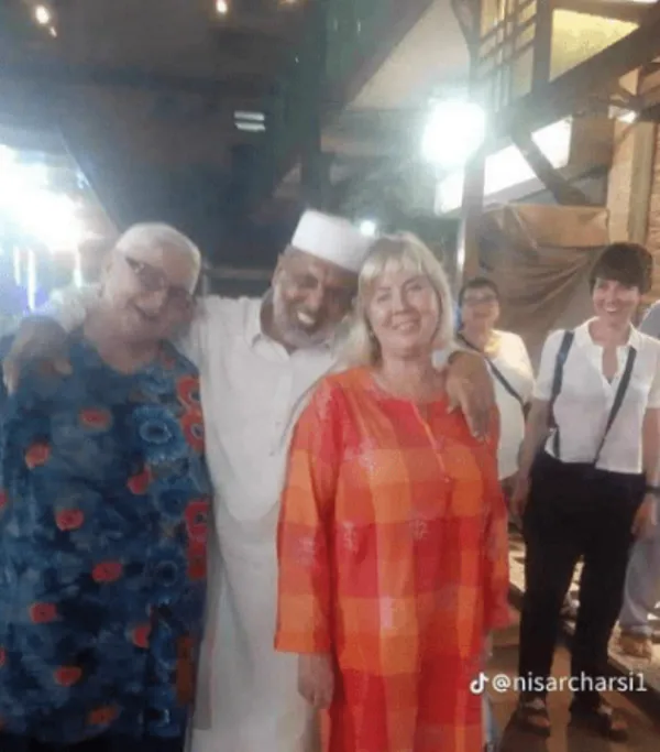 Nisar Charsi Tikka Owner embracing a tourist 
