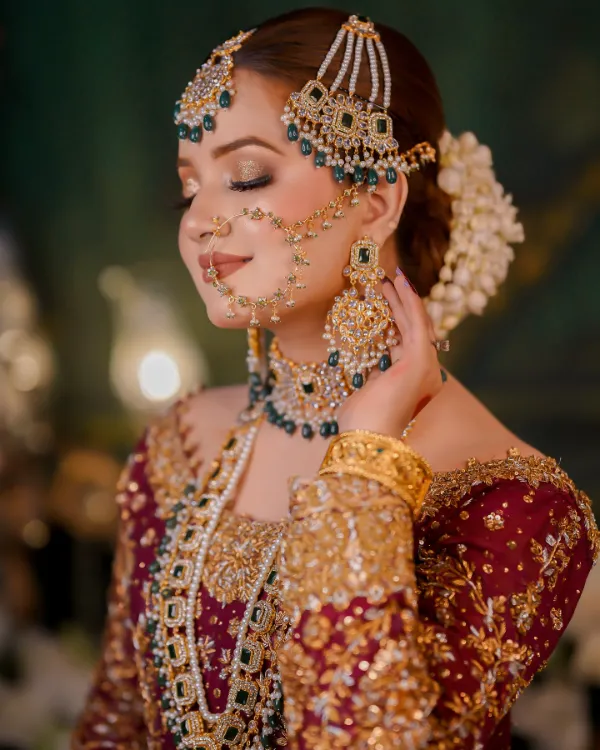She adorned with exquisite bridal head jewelry and a bejeweled nose ring.