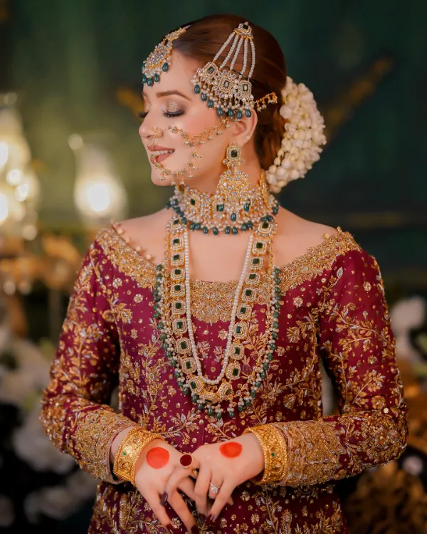 Rabeeca Khan in elegant bridal attire, poised gracefully with ornate gold jewelry