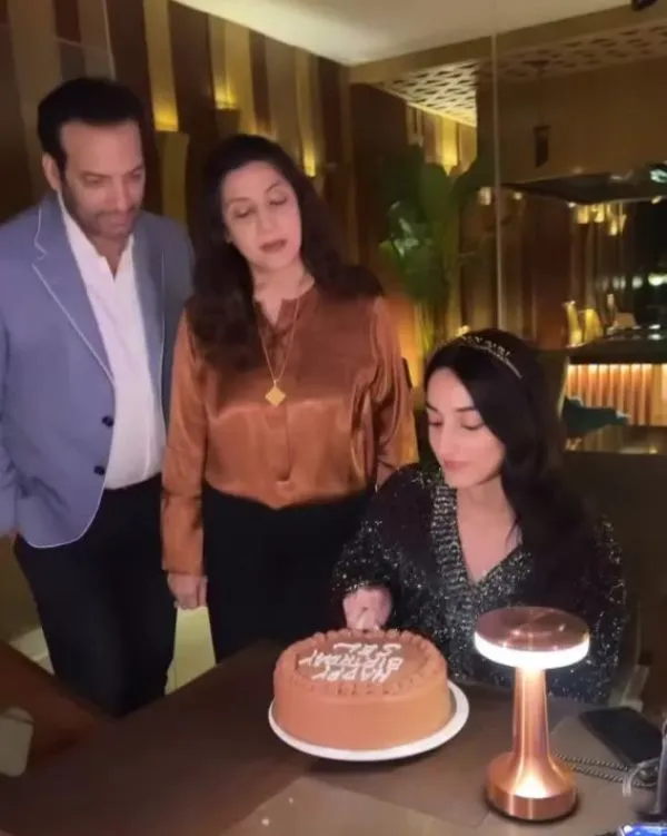 She cuts cake with her father and mother